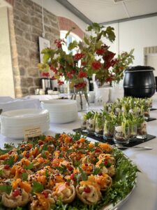 Valge linaga peolaud kaetud Catering Kene suupistete, inventari ja dekoratsioonidega.